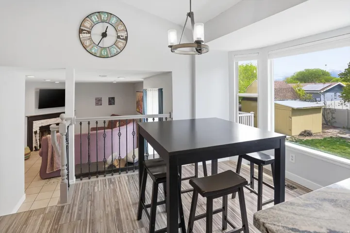 Dining area featuring light wood finished floors, lofted ceiling, and suspended lighting