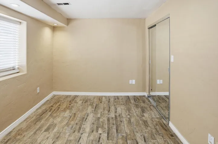 Spare room with wood finished floors and a textured wall