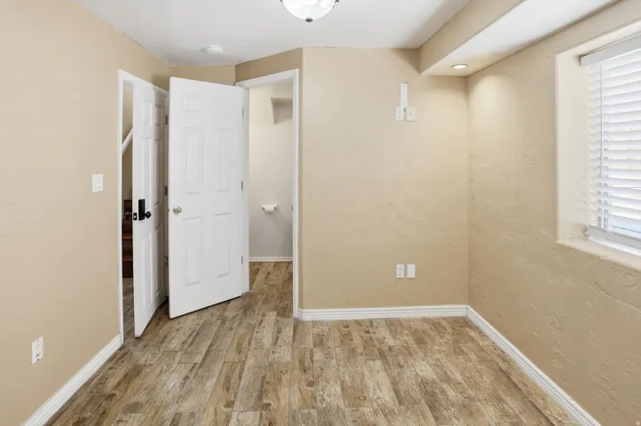 Unfurnished bedroom with light wood-style flooring, a textured wall, and recessed lighting