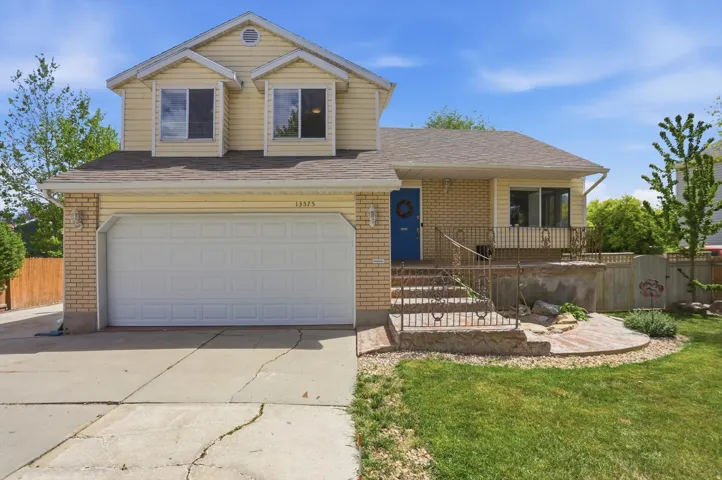 Traditional-style home with brick siding, concrete driveway, an attached garage, and a shingled roof