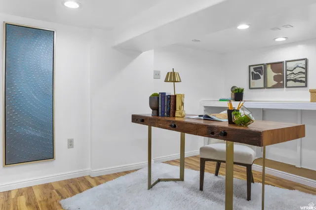 Office area featuring light wood finished floors and recessed lighting