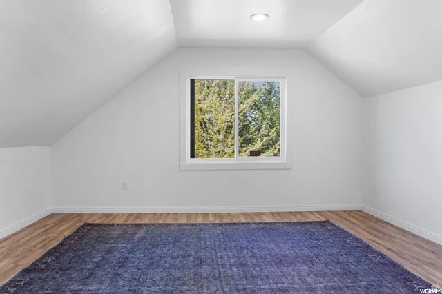 Additional living space featuring wood finished floors and baseboards