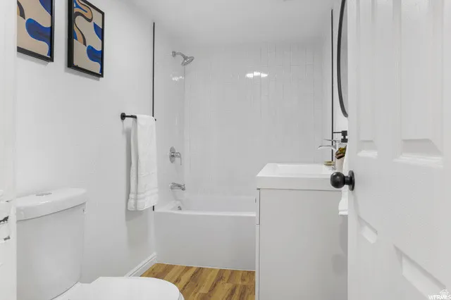 Bathroom featuring vanity, light wood-style flooring, and bathtub / shower combination