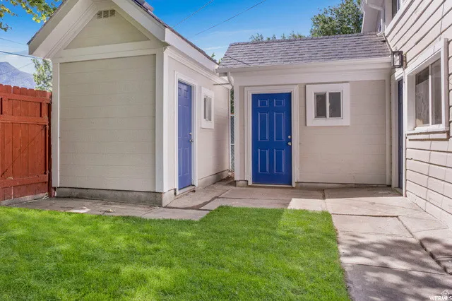 Doorway to property with roof with shingles
