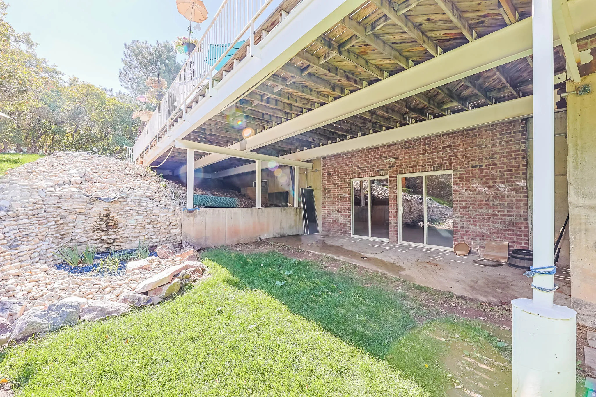 View of grassy yard featuring a patio area