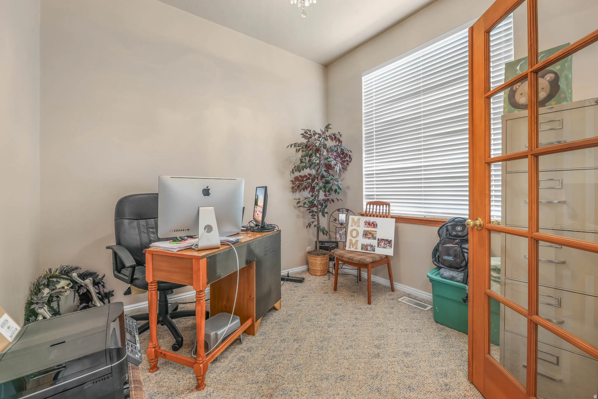 Office area featuring light carpet and baseboards