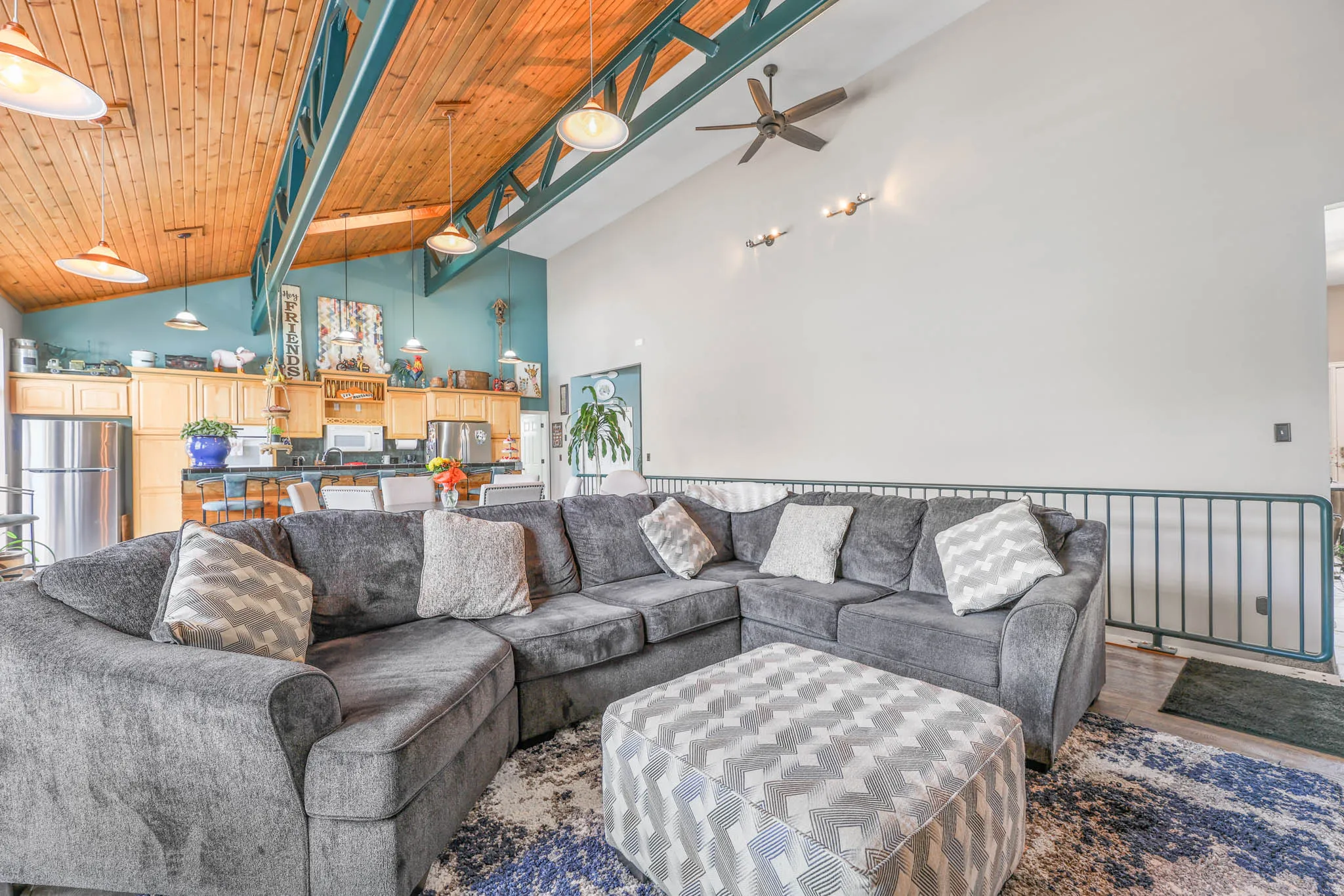 Living area featuring ceiling fan, wood finished floors, and a high wooden beamed ceiling