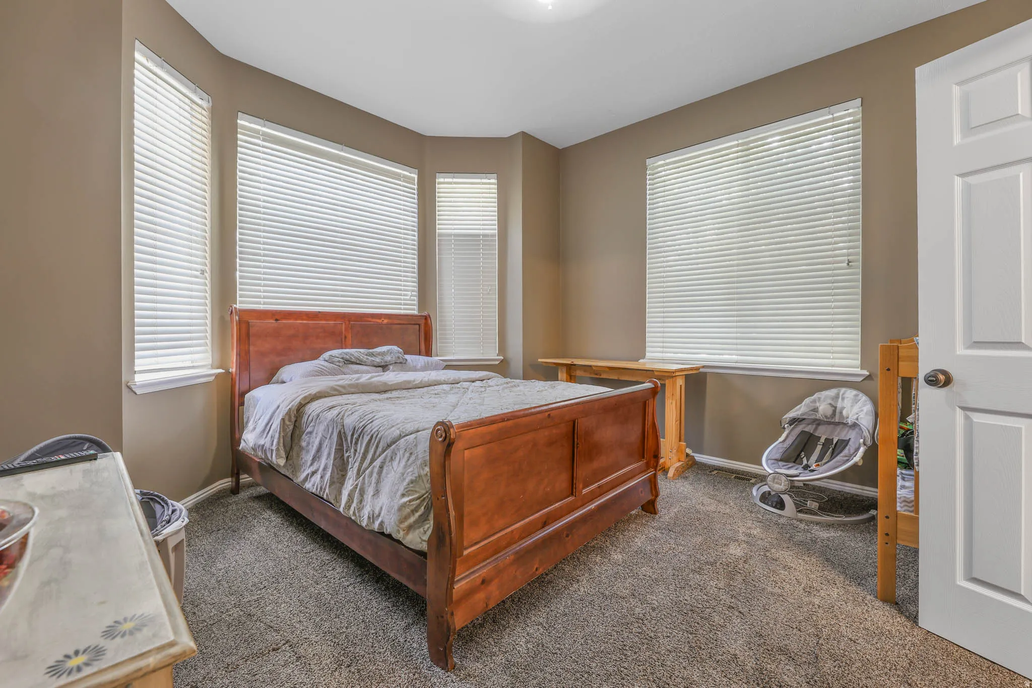 Bedroom featuring dark carpet and multiple windows
