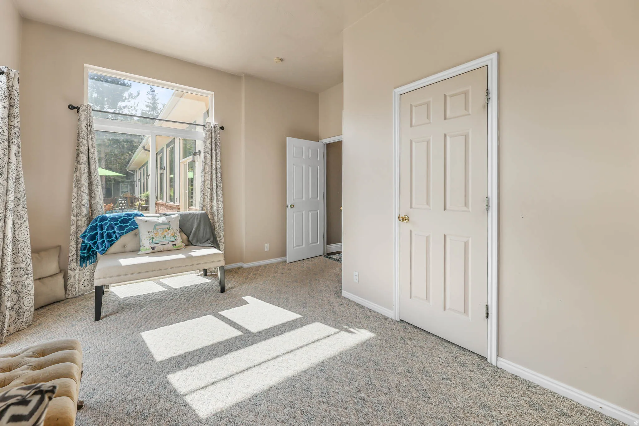 Living area featuring light colored carpet and baseboards