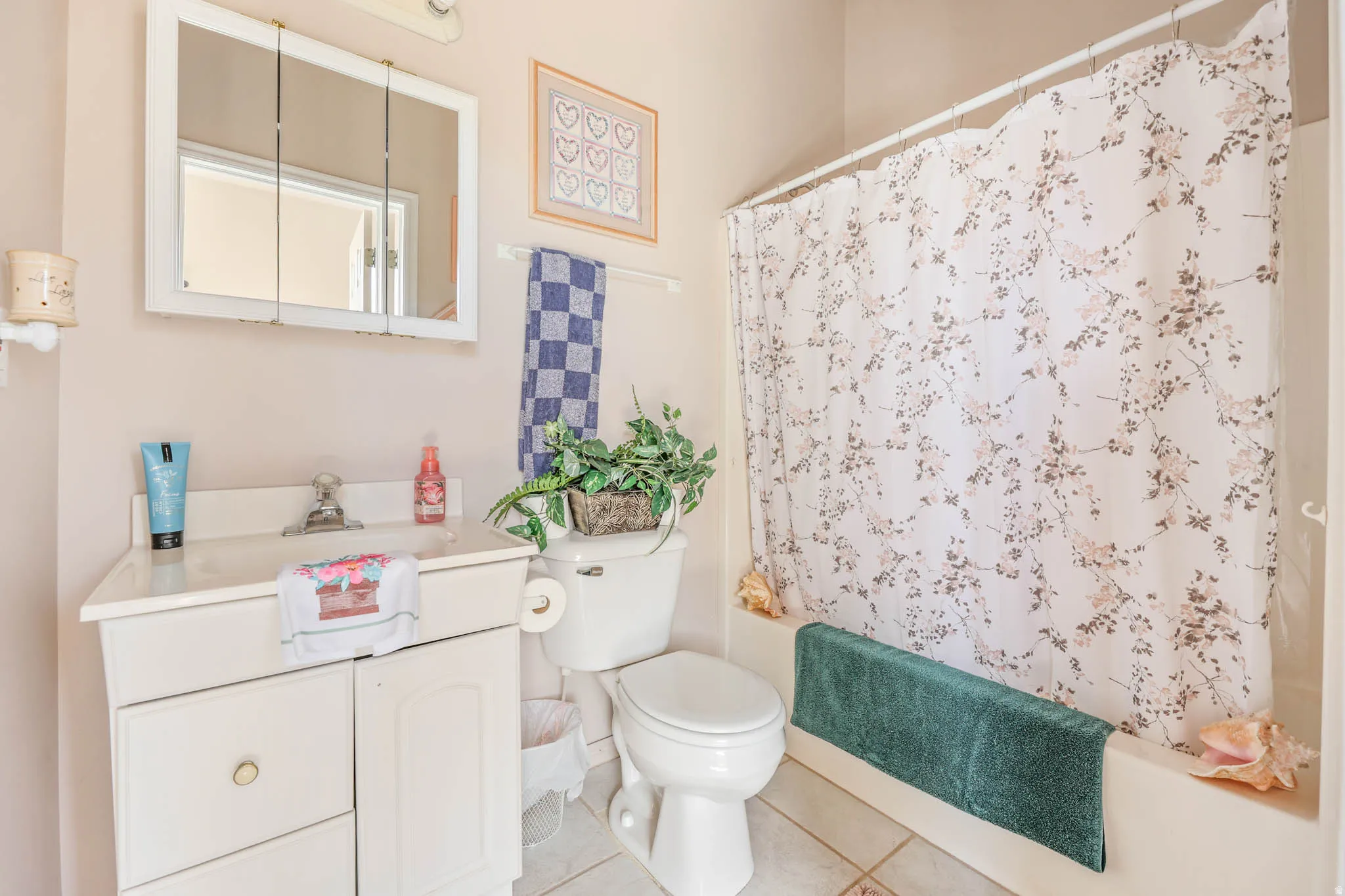 Bathroom featuring vanity, shower / tub combo, and light tile patterned floors