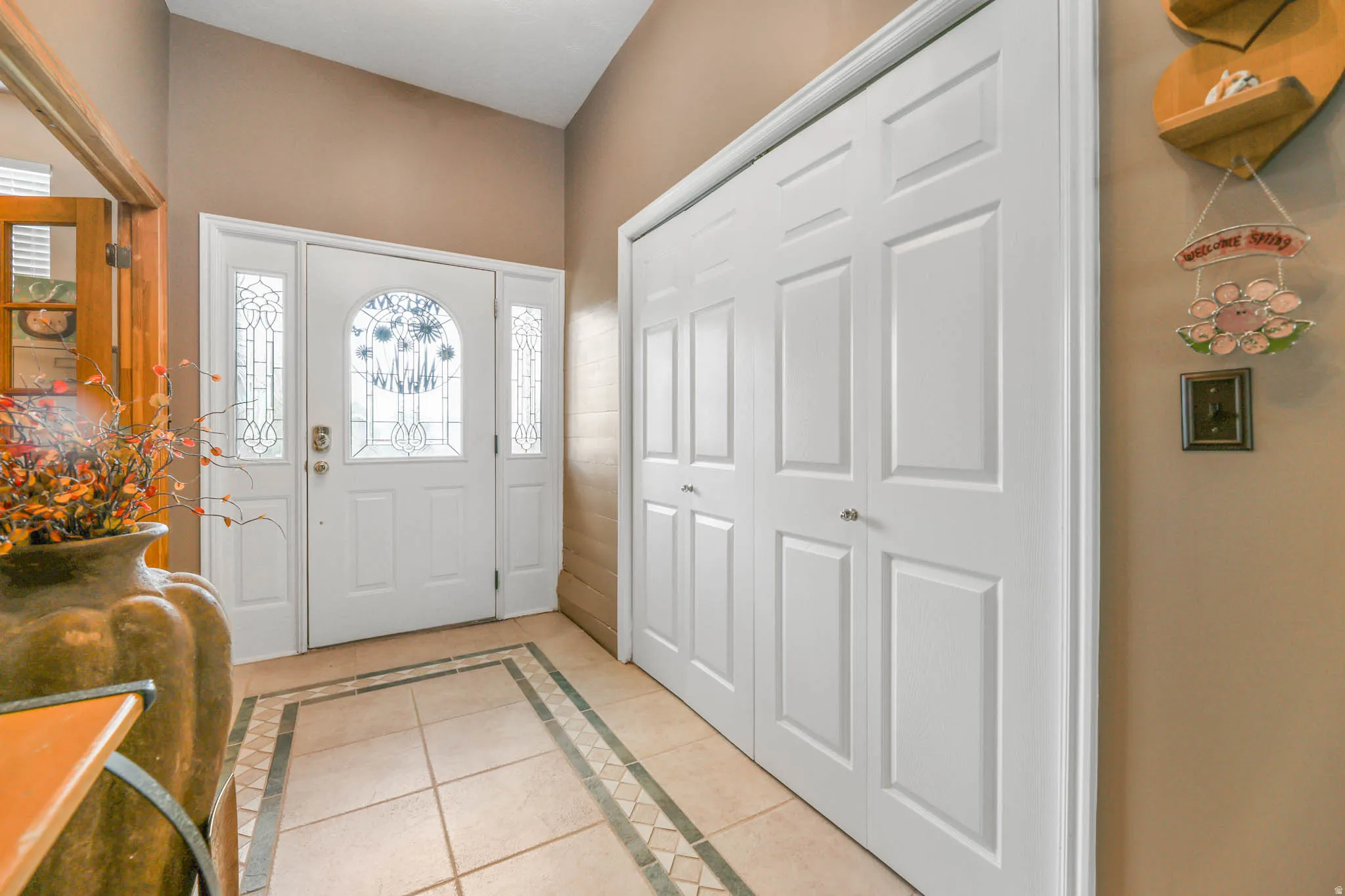 Entrance foyer with inlaid floor details and light tile patterned floors