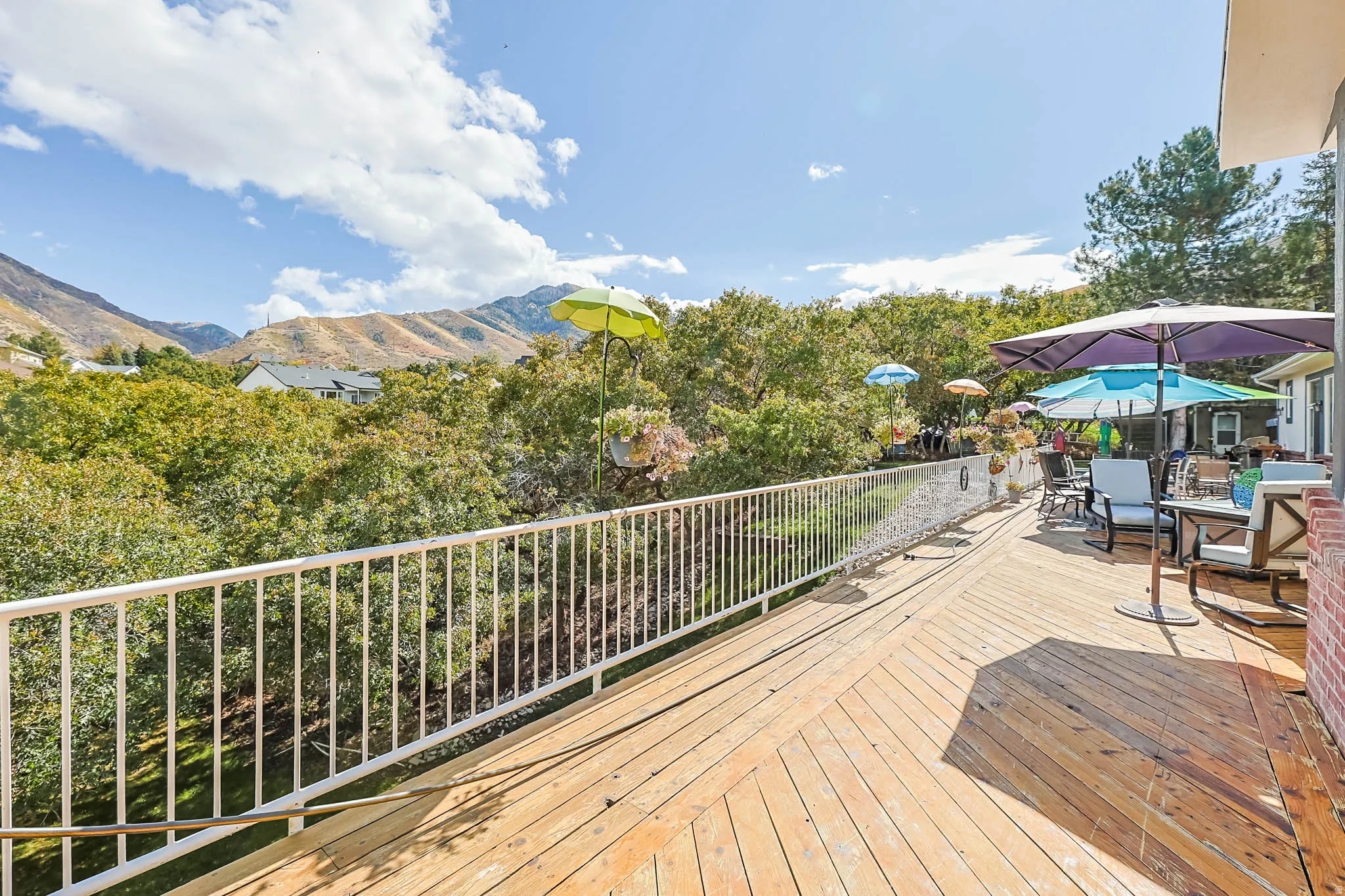 Wooden deck with outdoor dining space and a mountain view
