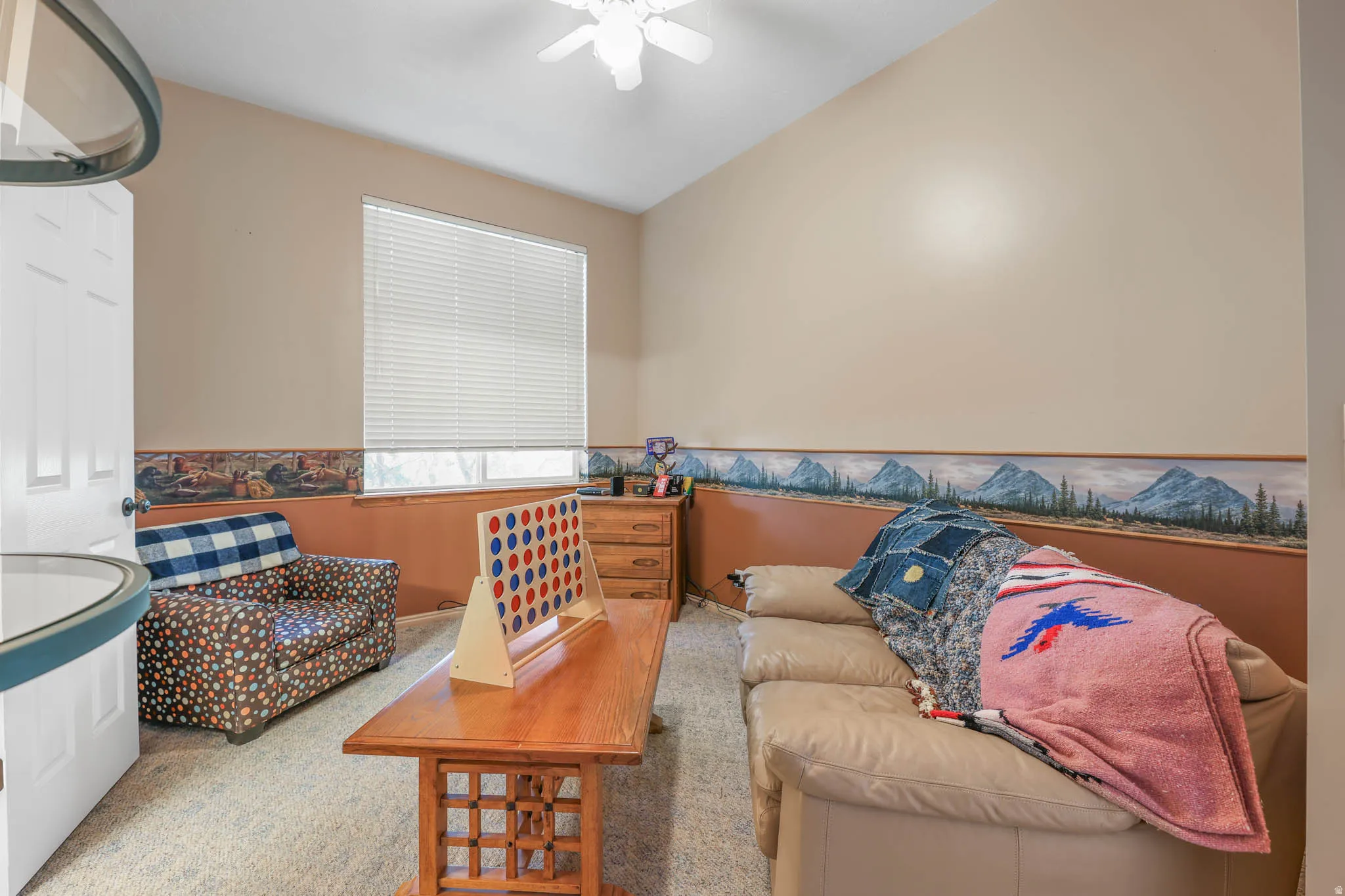 Sitting room with ceiling fan and a wainscoted wall