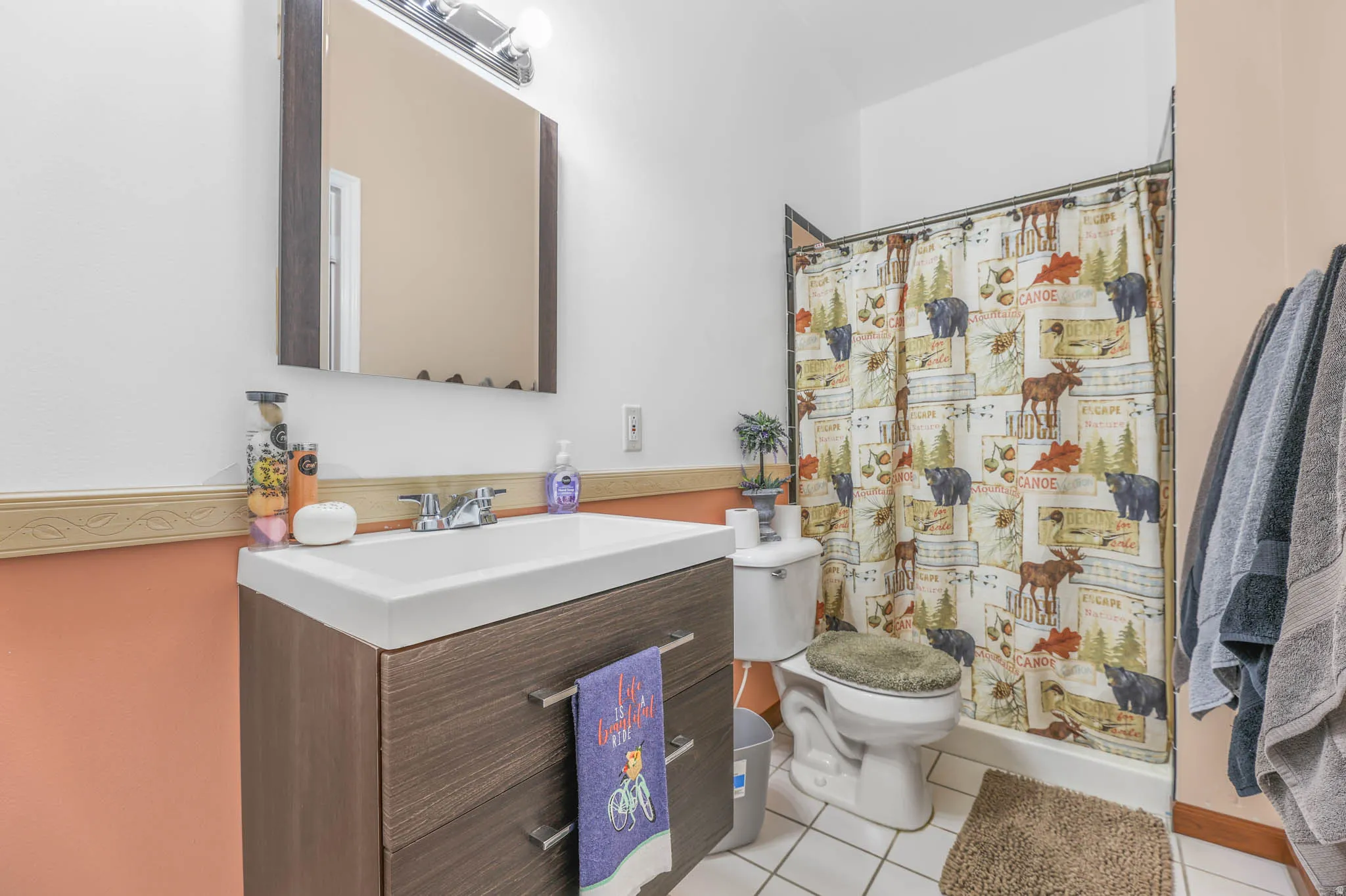 Bathroom featuring vanity, a shower with curtain, and light tile patterned floors
