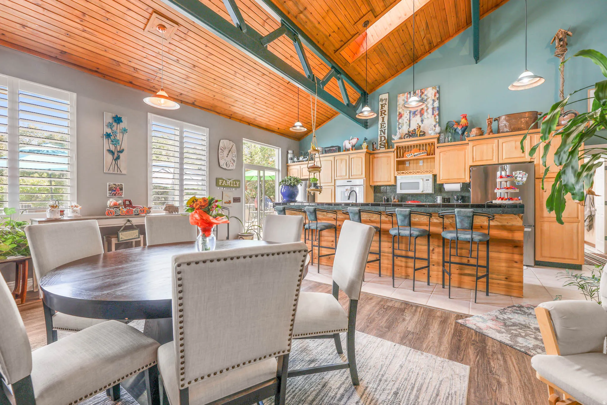 Dining area featuring a vaulted wood ceiling, light wood-style flooring, and a skylight