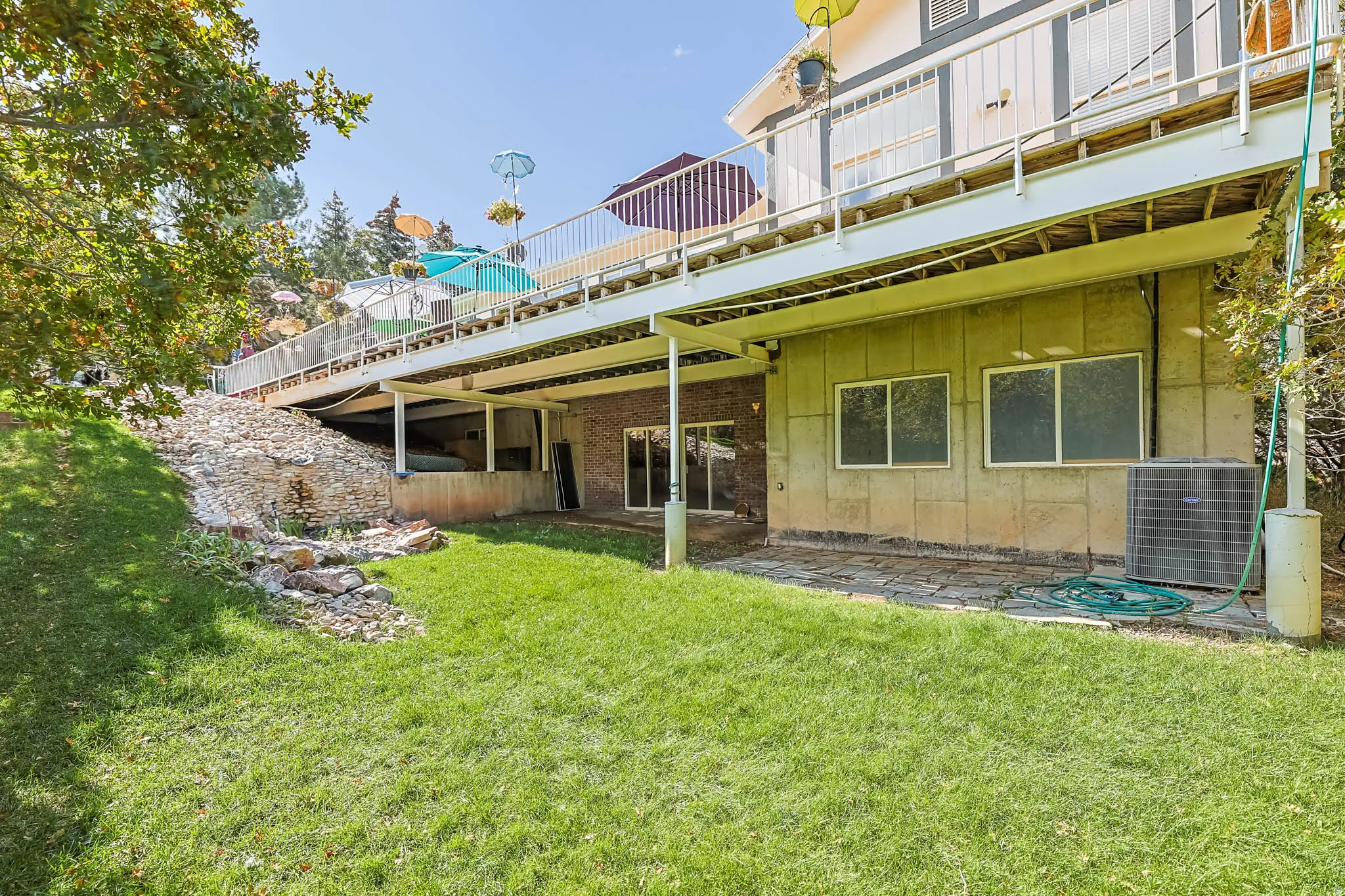 Rear view of property featuring a lawn, a patio, and board and batten siding