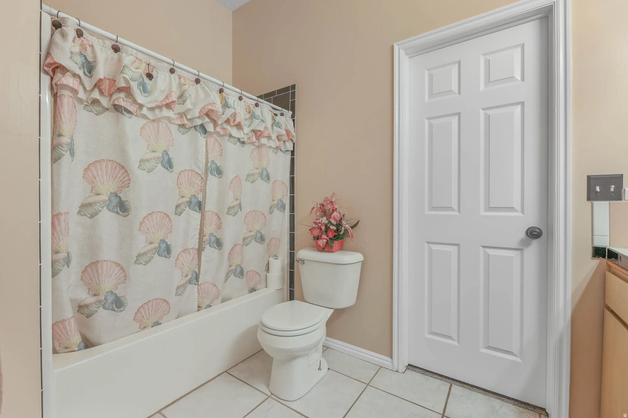 Bathroom with vanity, light tile patterned floors, and shower / tub combo with curtain