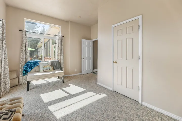 Living area featuring light colored carpet and baseboards