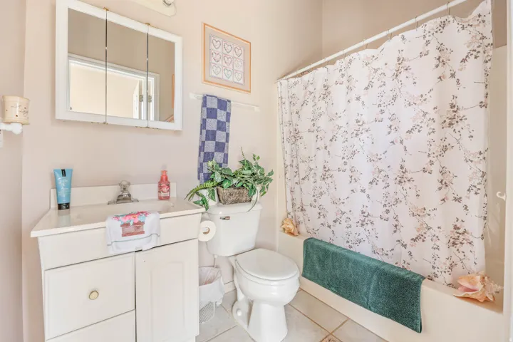 Bathroom featuring vanity, shower / tub combo, and light tile patterned floors
