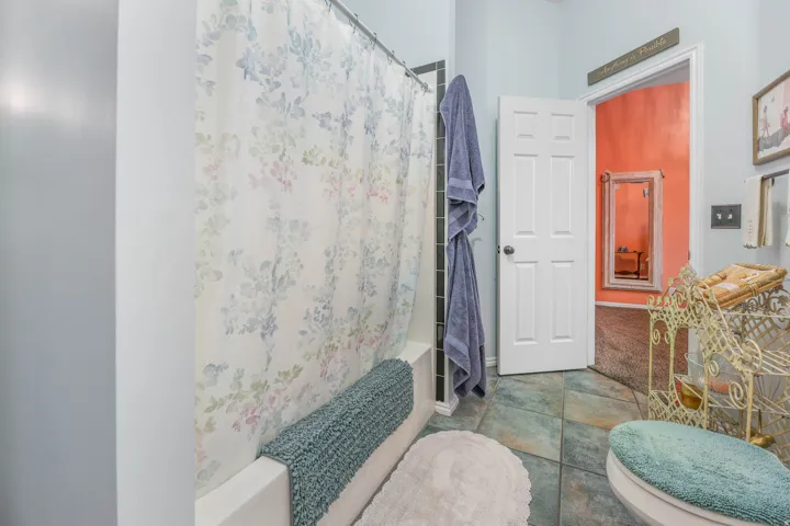 Full bathroom featuring shower / bathtub combination with curtain and tile patterned flooring