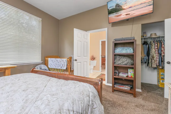 Carpeted bedroom with baseboards and a spacious closet