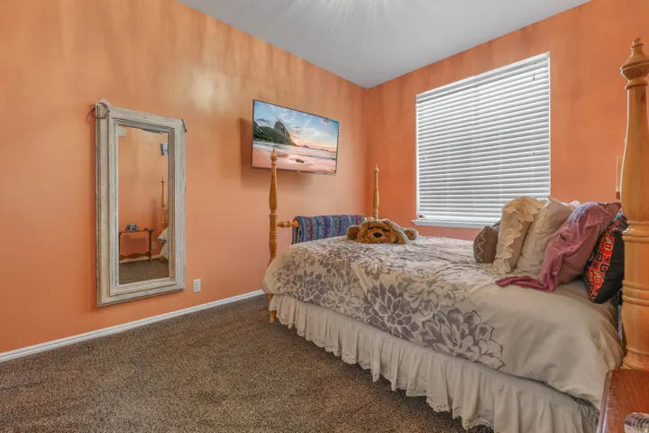 Bedroom featuring dark colored carpet and baseboards
