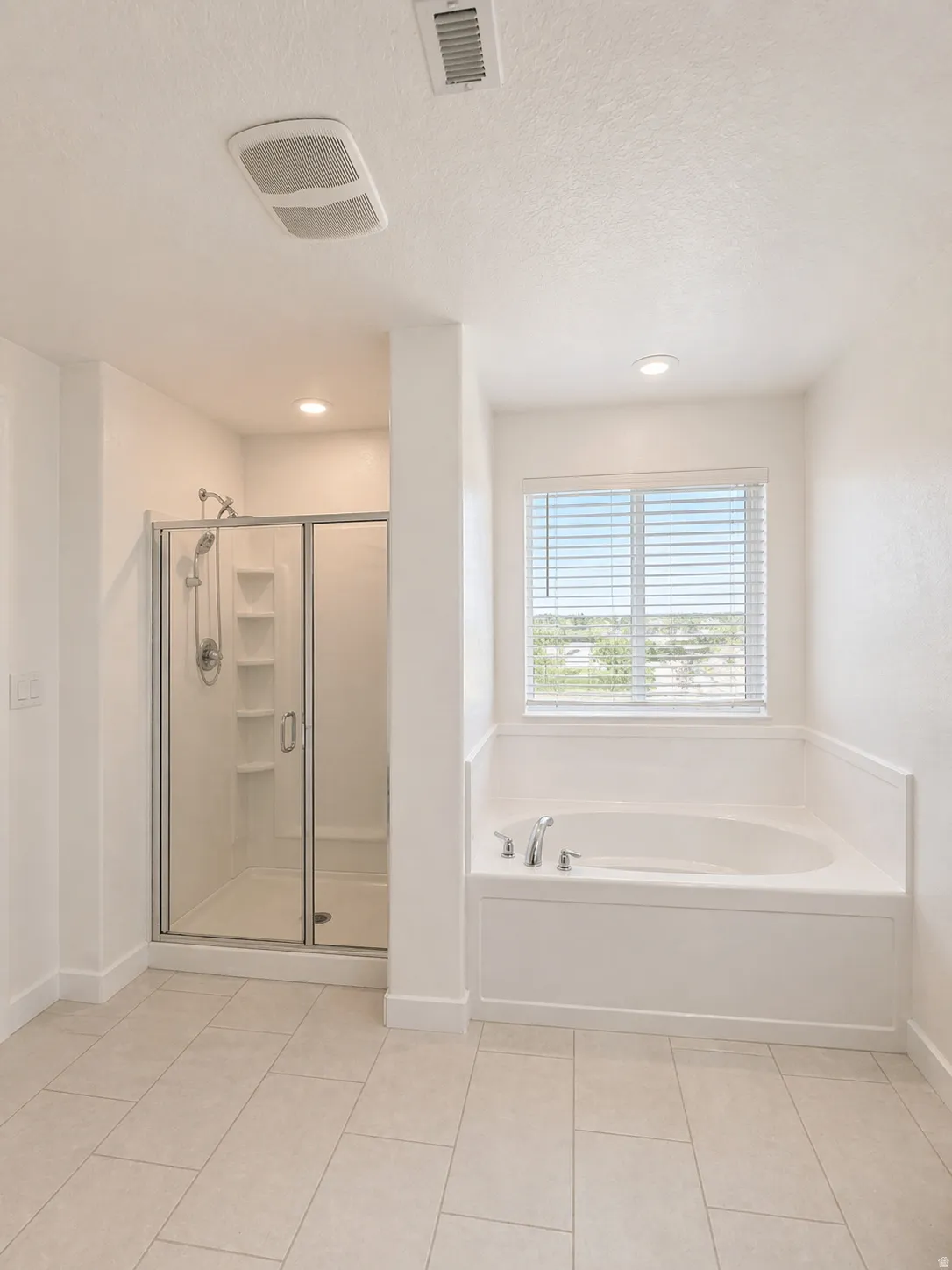 Bathroom with a garden tub, a shower stall, a textured ceiling, and recessed lighting