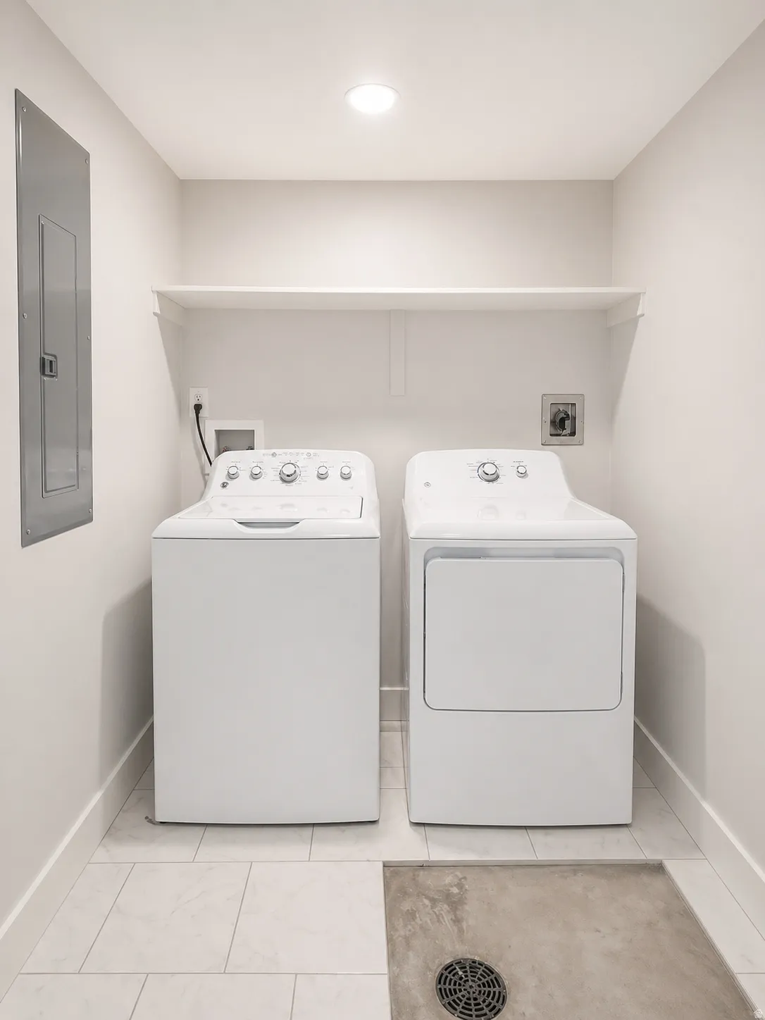 Laundry area with electric panel and washer and dryer