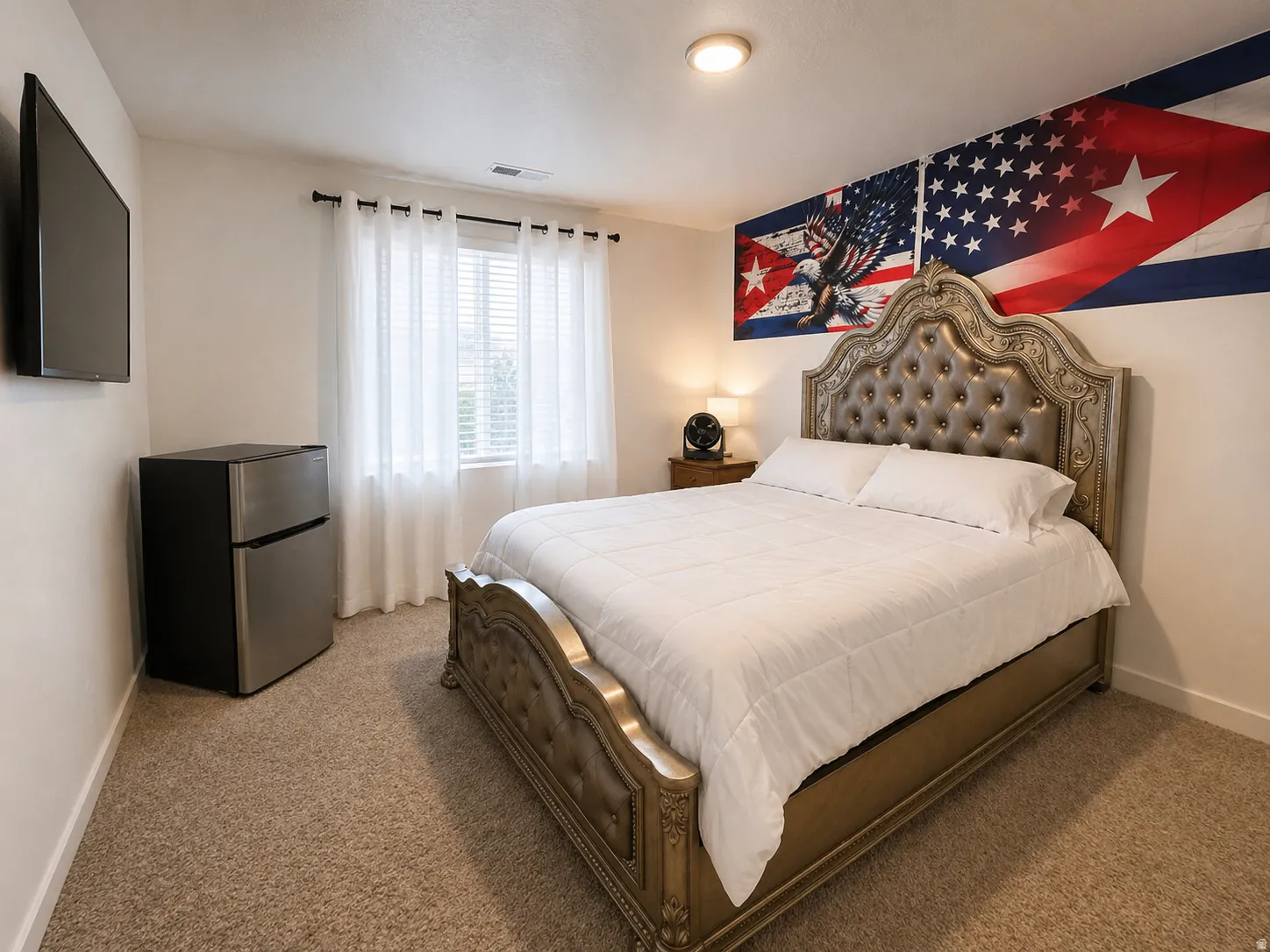 Bedroom with freestanding refrigerator and carpet