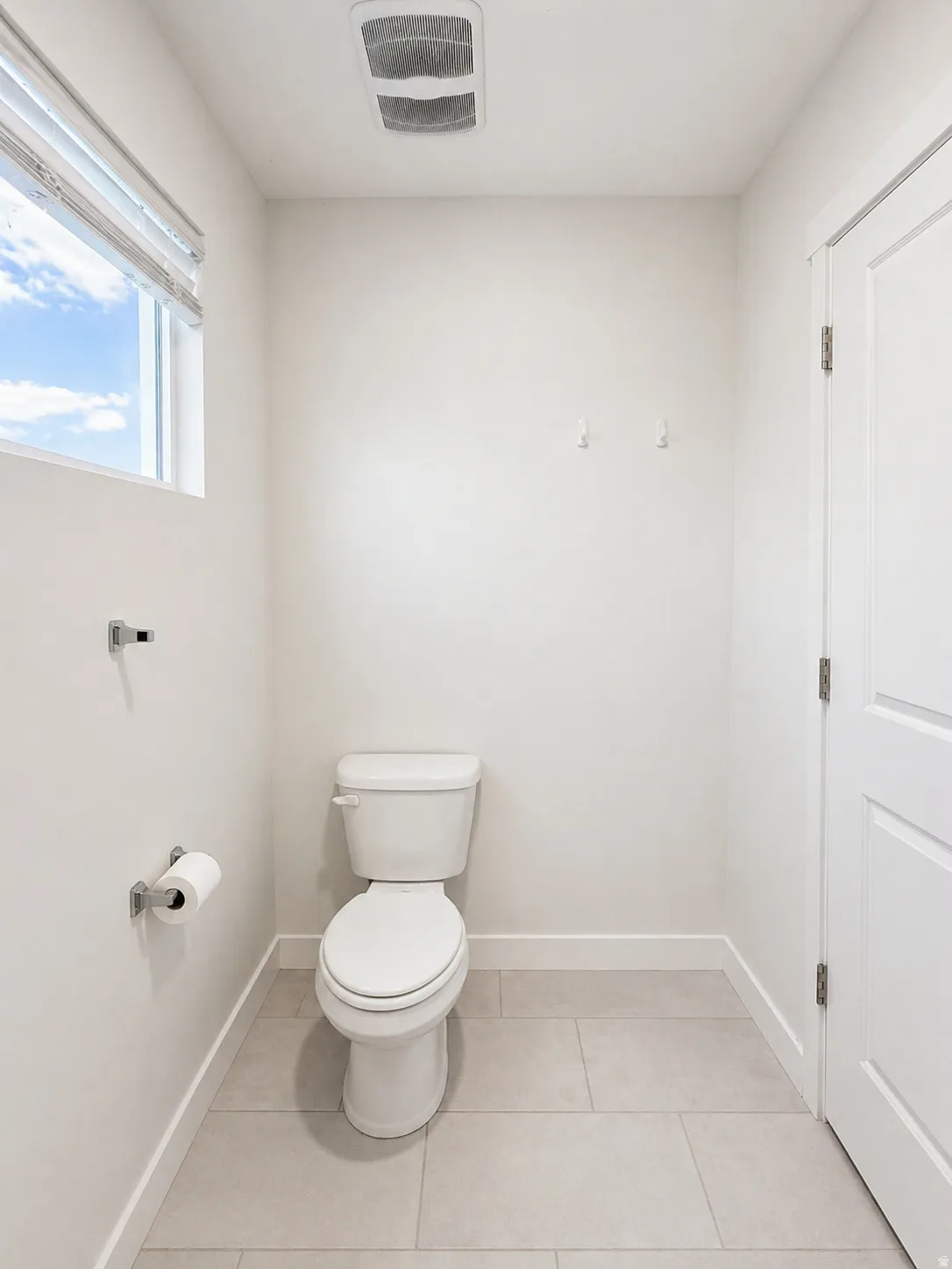 Bathroom with toilet and light tile patterned flooring