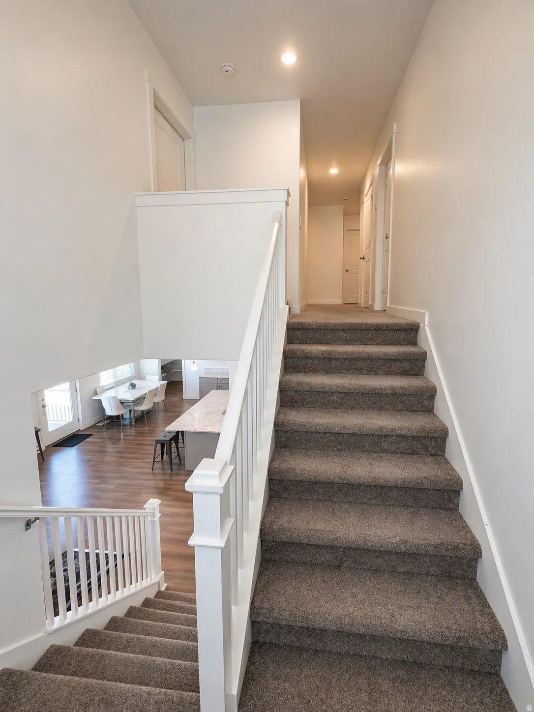 Stairs with recessed lighting and baseboards