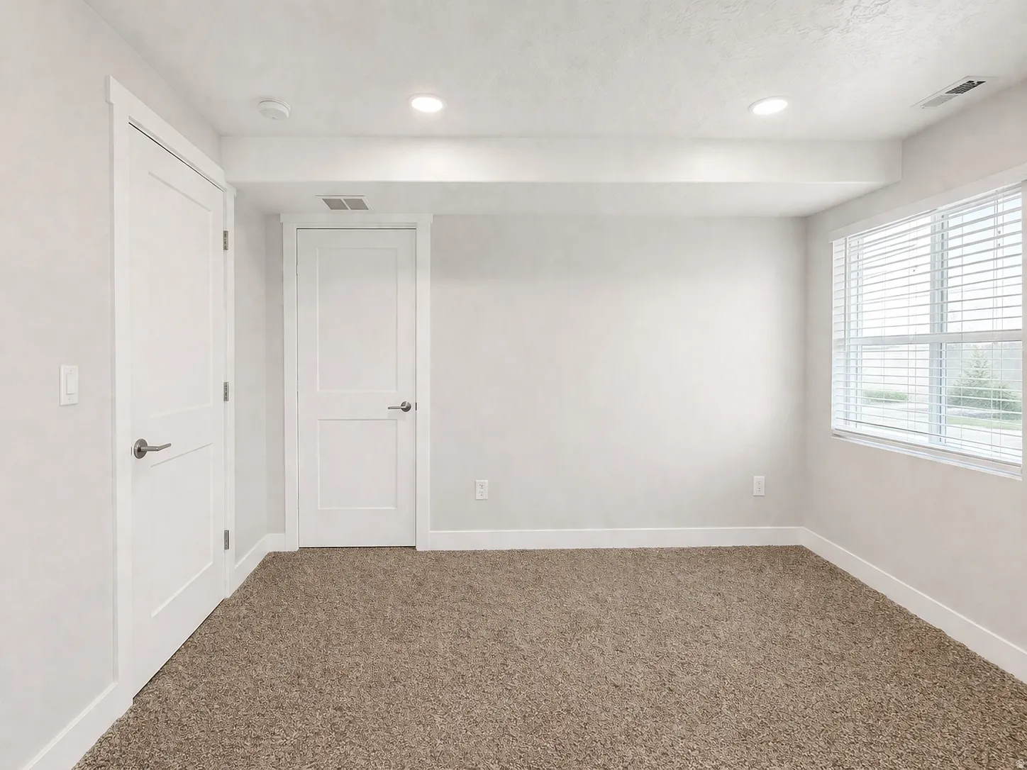 Carpeted spare room with baseboards and recessed lighting