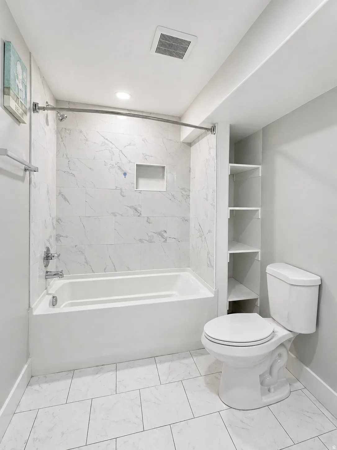 Bathroom featuring tub / shower combination and light marble finish floors