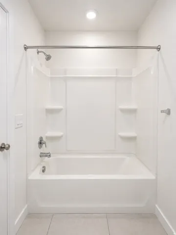 Full bathroom featuring light tile patterned floors and shower / bath combination
