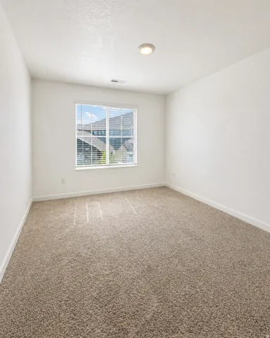 Carpeted empty room with baseboards