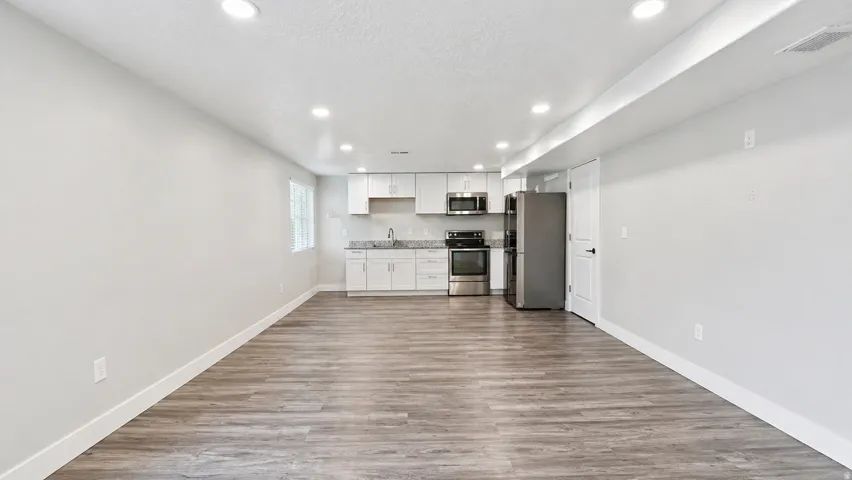 Kitchen featuring white cabinets, recessed lighting, stainless steel appliances, dark wood-style floors, and a textured ceiling
