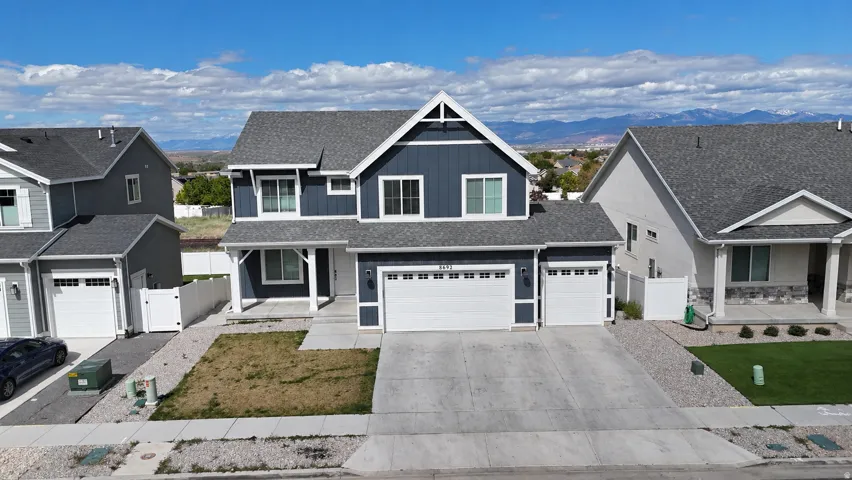 View of front of home with covered porch, a gate, board and batten siding, concrete driveway, and an attached garage