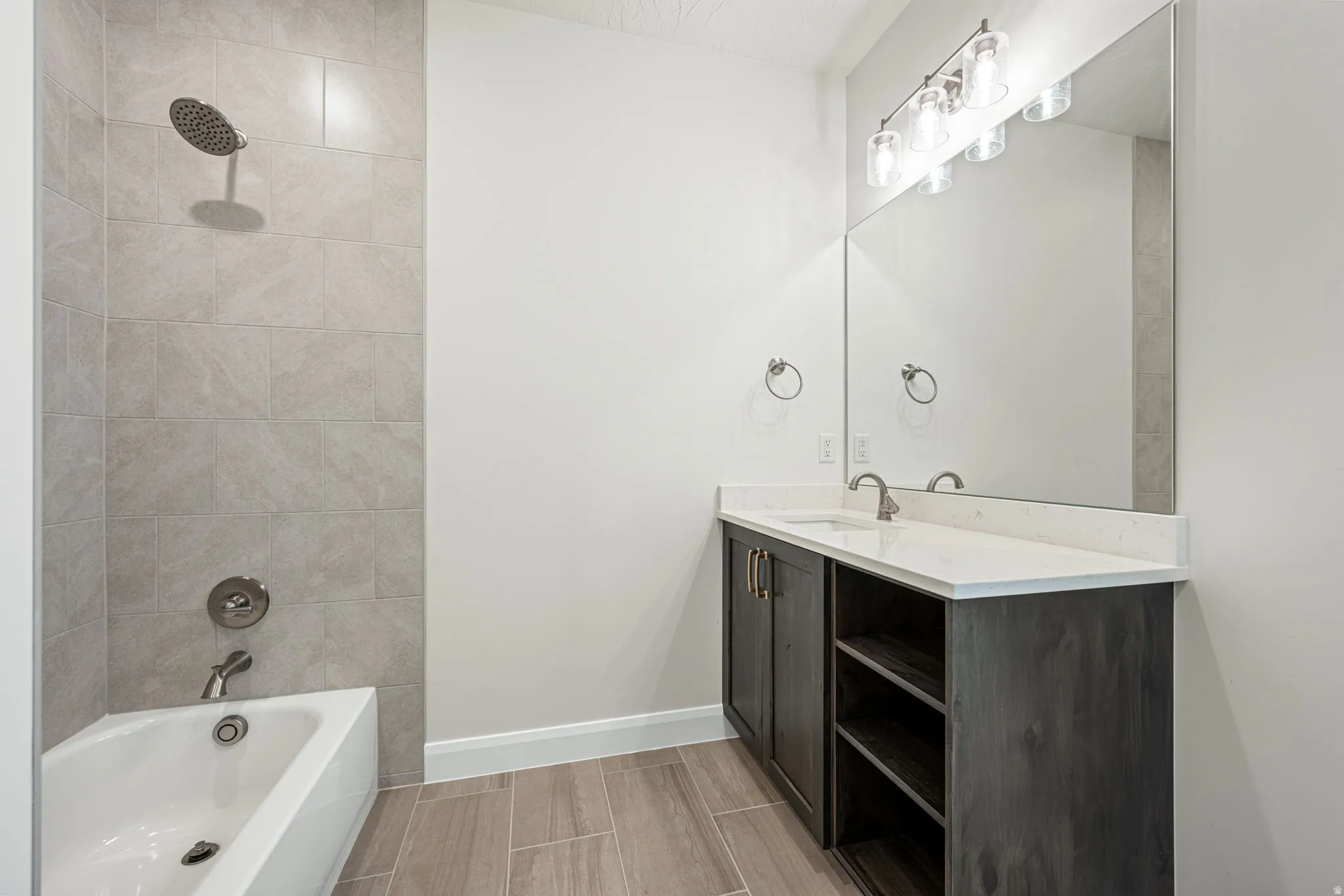 Bathroom featuring a single vanity with a white countertop, dark wood-finish cabinetry, and an integrated rectangular sink