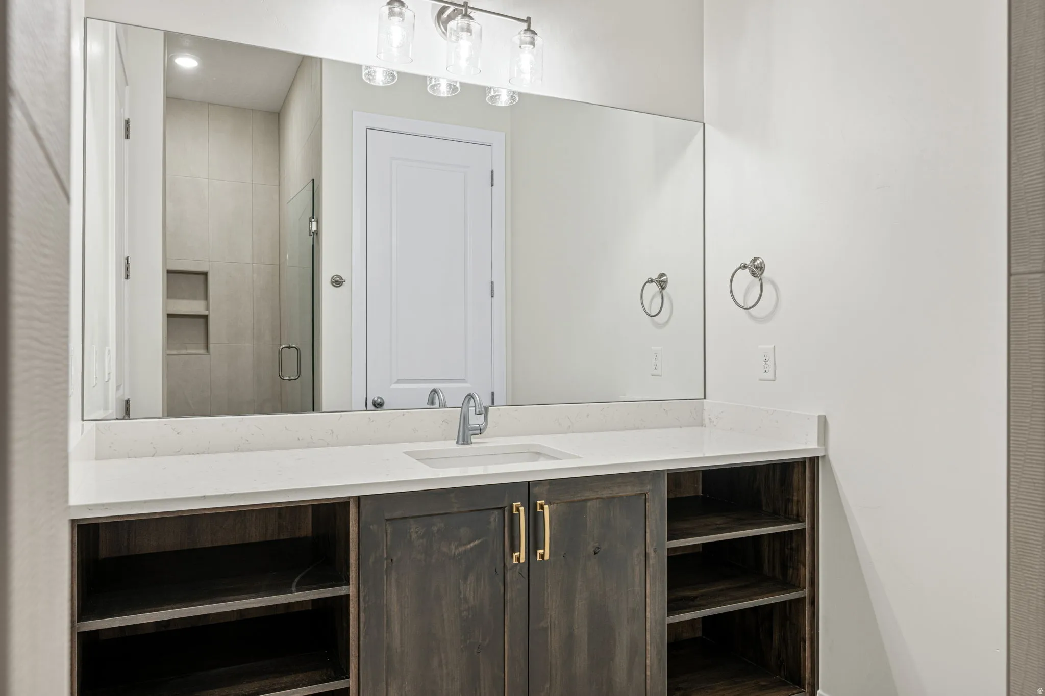 Bathroom vanity with a rectangular undermount sink, a chrome faucet, and a light-colored countertop