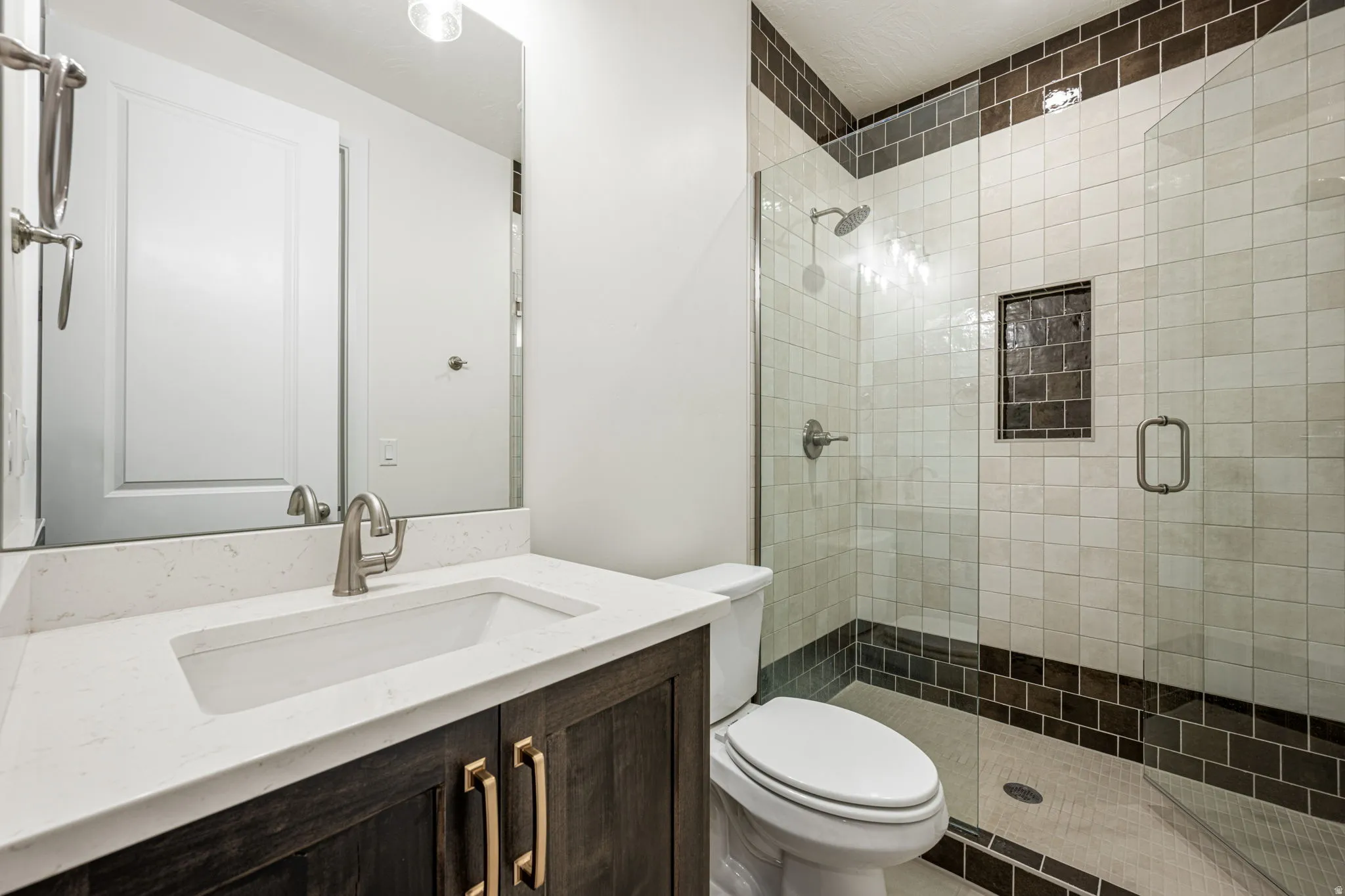 Spacious bathroom featuring a dark wood-finish vanity with gold-tone hardware, a white countertop, and an undermount sink