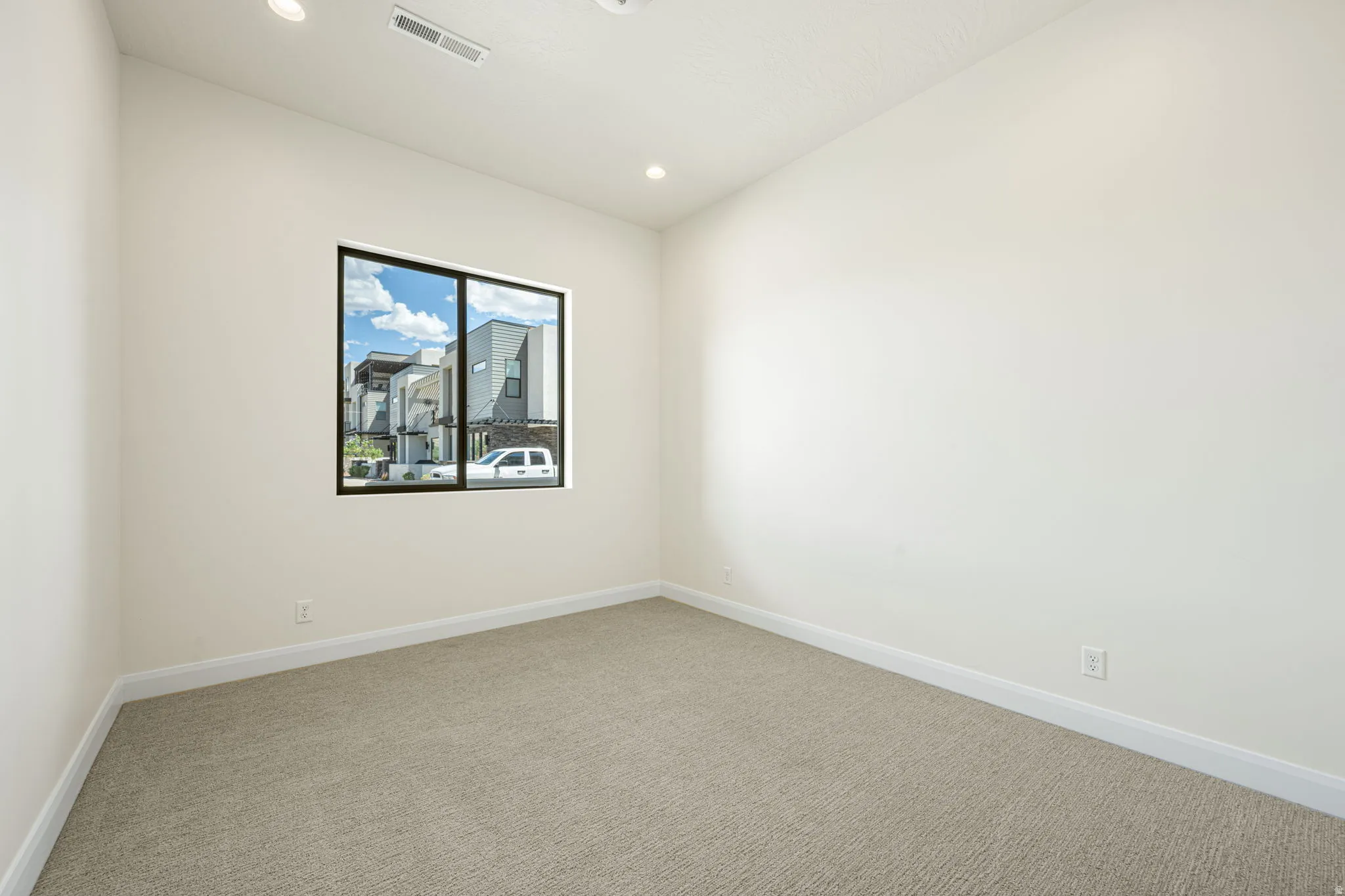 Neutral-toned room with light beige carpeting and white baseboards