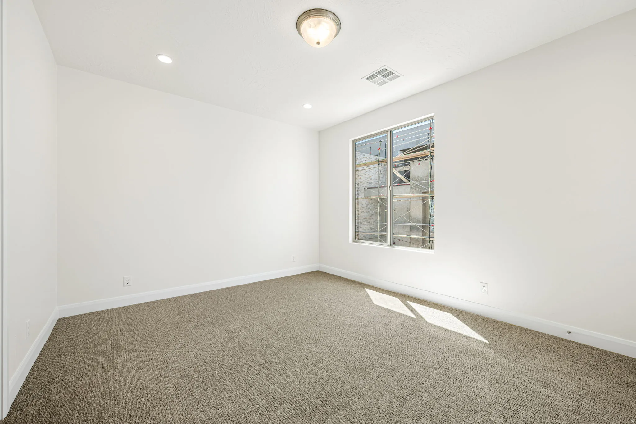 Neutral-toned carpet flooring with white baseboards and walls