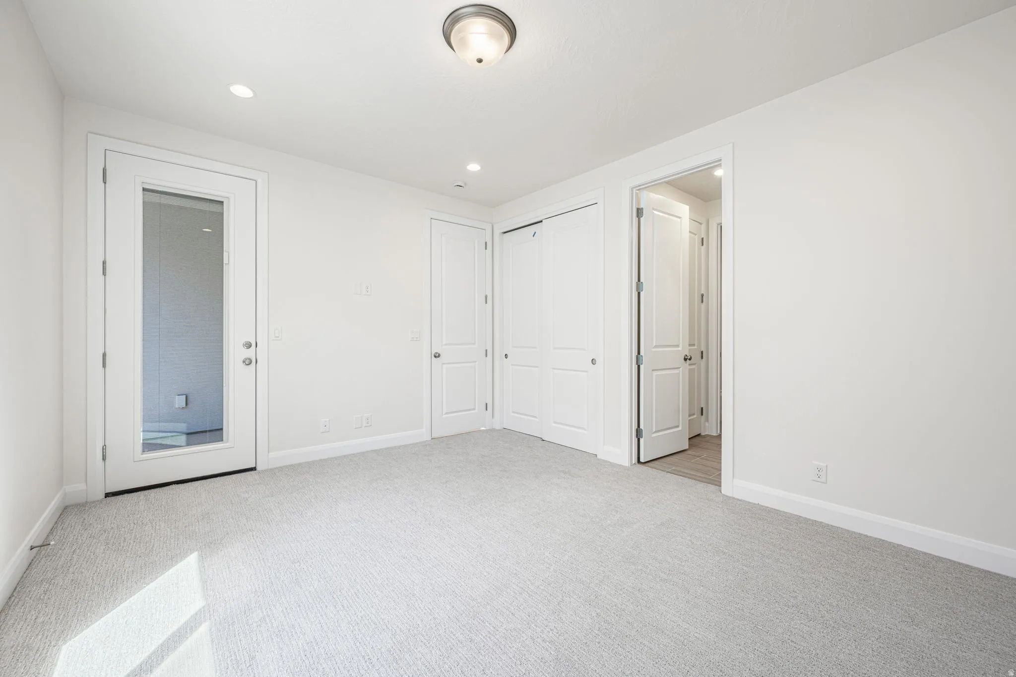 Carpeted room with recessed lighting and a flush mount ceiling fixture