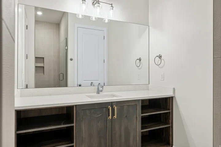 Bathroom vanity with a rectangular undermount sink, a chrome faucet, and a light-colored countertop
