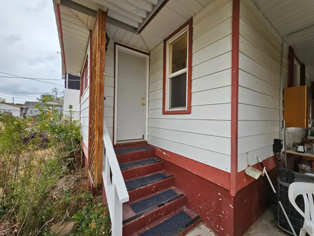 View of exterior entry featuring covered porch