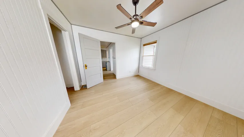 Light wood-finish flooring complements white paneled walls