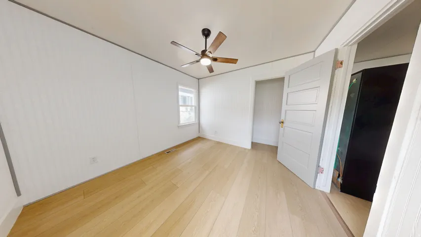 Light wood-finish flooring complements white paneled walls