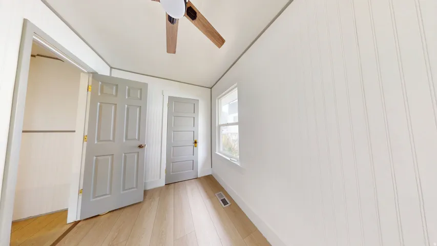 Light wood-finish flooring complemented by white beadboard paneling