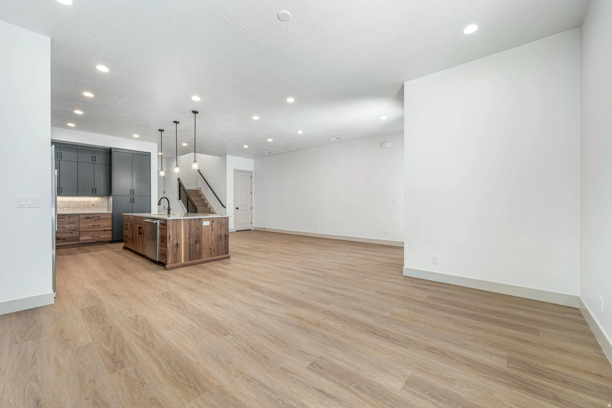 Open-concept living space featuring wood-finish flooring and recessed lighting