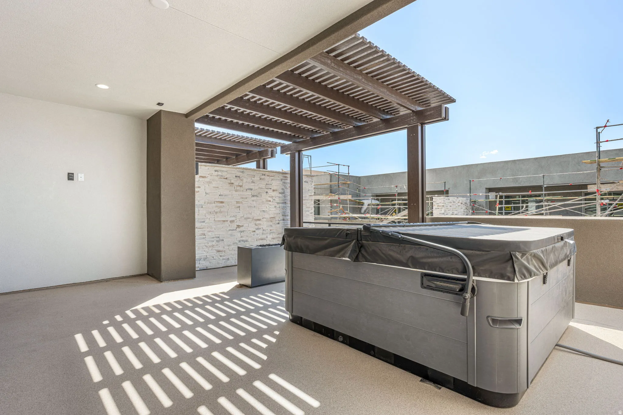 Rooftop patio with built-in spa, pergola, and recessed lighting